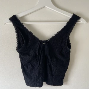 Svart top i spets - En söt svart top med knytning i fram i storlek Xs. Köpt i Frankrike <3