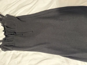 Klänning - En svart klänning, ganska kort.