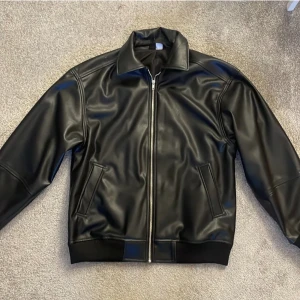 Bomberjacka i skinn - Bomberjacka i skinnimitation från H&M. Storlek xxs, men oversize. As snygg men får ingen användning för den. 