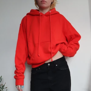 Röd Weekday hoodie - Röd oversized hoodie från Weekday. Står att den är XS men den är oversized så det är snarare en L. Tyvärr så är den ganska nopprig, inget som stört mig men bra att veta innan köp! Den har även tre små målar färg fläckar på ena ärmen (skriv för bild) ☎️