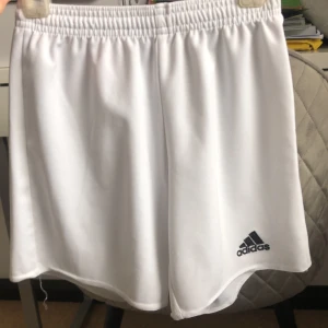 Vita Adidas shorts  - Ett par vita adidas short. 9-10 år. Sköna och har även rep! Säljer pågrund av att dom är för små.