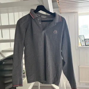 moncler piké grå - den är i storlek large men passar från ca 173-180 den är i väldigt fint skick då jag inte använt den mer än 5 gånger typ. priset kan diskuteras
