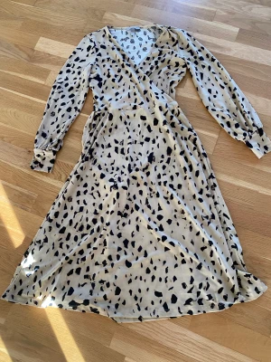  klänning  - En beige klänning med svarta prickar från H&M i storlek xs. Jättefin klänning och i princip oanvänd då den är för liten.