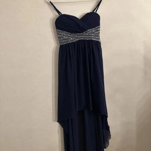 Festklänning - Snygg blå festklänning. Lång baktill och kort framtill. 