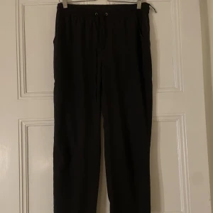 Svarta byxor från Vero Moda - Svarta byxor i tunt material i strl M från Vero Moda. Snörning i midjan och framfickor. Endast använda ett fåtal gånger.
