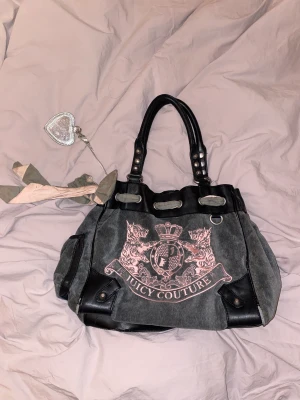 Juicy couture väska  - Fake-lädret på insidan och på remmen som hänger är slitna och har smulat.  Men i övrigt bra skick