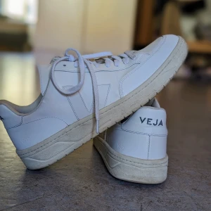 Veja sneakers, vita, stl45 - Vita sneakers från Veja. Storlek 45. Sparsamt använda och i fint begagnat skick. Skorna har små slitningar kring snörena (bild 3), ingenting som stör men tänkte att det kunde vara värt att nämna :) Har tyvärr inte kvar orginallådan.