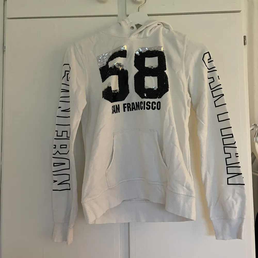 En vit hoodie med paljetter ifrån h&m som aldrig kommer till användning längre . Hoodies.