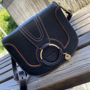 Väska från See By Chloe - Äkta See By Chloe väska. Svart läder med röda & guldiga detaljer😍 Fick väskan som present av mitt ex nu vill jag bli av med den. Köpt på Zalando