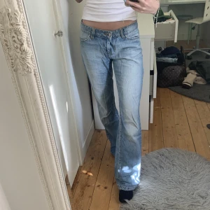 Lågmidjade jeans - Ett par lågmidjade jeans i superfin tvätt med glitter/paljett- detaljer på fickorna. Lite slitna längst ner se bild två. 💙💙