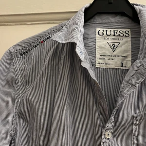 Billig Guessskjorta - Randig guessskjorta. Fint skick endast använd fåtal gånger! Liten i storleken passar en normal M