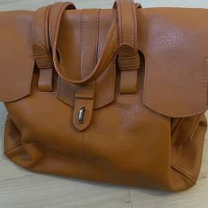 väska - super fin väska som aldrig använts, inga repor eller liknande. ca 35cm bred och 30cm lång