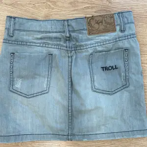 Svin cool grå lågmidjad mini jeans kjol med nitar från märket ”troll”.