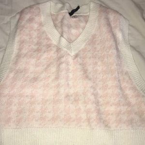 Säljer denna stickad väst som aldrig e använd  - Denna stickade västen e jäkligt fin och kan vara perfekt till nästan allt om det blir lite kallt e rosa och vitt och dessutom alldrig använd 
