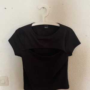 Ribbad tshirt  - Svart ribabd tshirt med öppning vid bröstet.