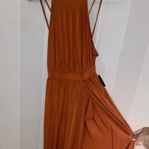 Klänning  - Sjukt snygg lång klänning från Nelly. Prislappen kvar. Perfekt för sommaren och stranden. Klänningen har en öppning mellan benen och ger därmed en sjuk figur till kroppen. Aldrig använt