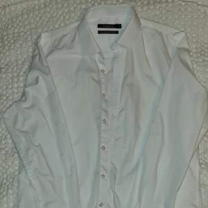 Vit skjorta köpt på Dressman i storlek medium.   Vita knappar, fläckfritt djur o rökfritt.   Nyskick, använd 3 gånger. Säljes p.ga för liten.