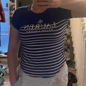 Ralph Lauren randig t-shirt  - Är 178, sitter tajt, kortärmad, randig tröja i blått och vitt som är i ganska bra skick. Nypriset var 499kr. Passar bra på sommaren, luftig tröja i skönt material!