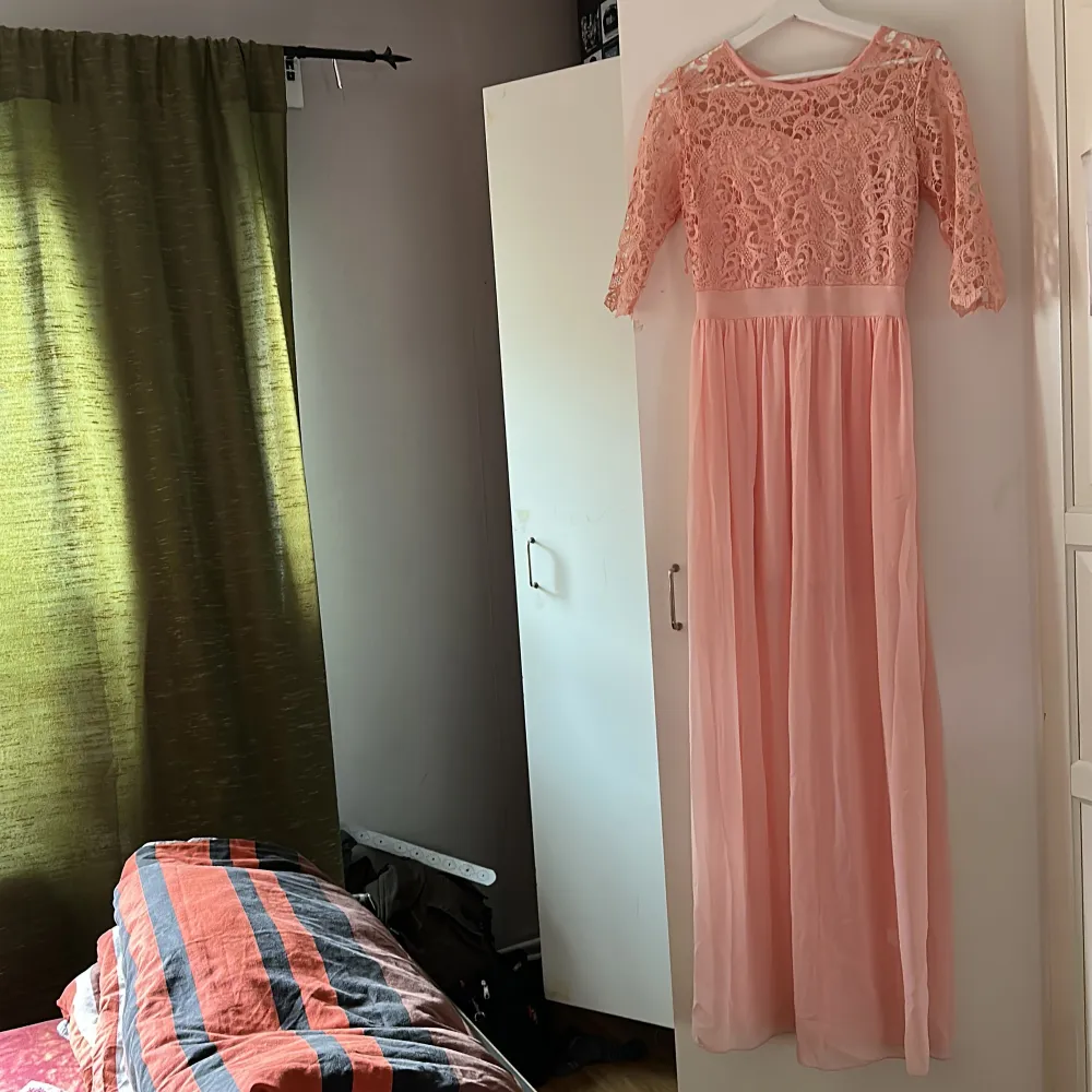 Light peach/ ljus rosa lång klänning. Den har spetsupptill och sedan en tunn lång kjol. . Klänningar.