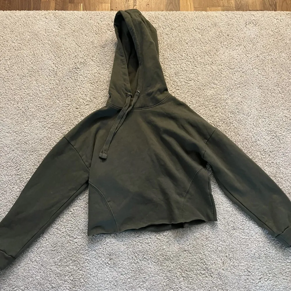 En mörkgrön hoodie som är lite kortare, med snöre och aldrig använd. Från lager 157 storlek M men passar även S då den är lite kort för mig i armarna😊. Tröjor & Koftor.