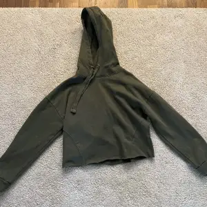 En mörkgrön hoodie som är lite kortare, med snöre och aldrig använd. Från lager 157 storlek M men passar även S då den är lite kort för mig i armarna😊