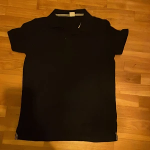 Skjorta - Mörkblå skjorta med knappar endast vid halsen, nästan helt oanvänd och riktigt snygg.