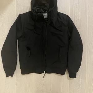 Warp jacka i svart - Svart höst- vinterjacka med luva och fickor. Sparsamt använd. Mycket fint skick. Märke: Warp. Rök- och djurfritt hem.