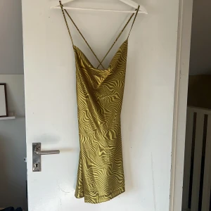 Kort satinklänning - Klänning öppen i ryggen. Visar på sista bilden från nätet. I nyskick. Storlek L men använder den som en M.