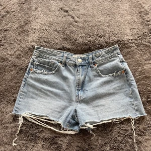 Ljusblå jeansshorts från Stradivarius - Ljusblå jeansshorts från Stradivarius med slitningar. Storlek 36.