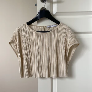 Beige topp - Säljer denna festliga beige skimrande topp från NA-KD. Kort i modellen, knappt använd. Tror inte den säljs längre🤍