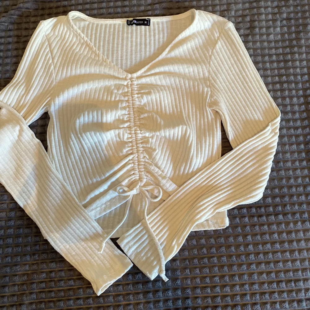 En fin vit långärmad tröja från New yorker i storlek M. Ribbat material med knyt band. Använda fåtal gånger och i fint skick . Tröjor & Koftor.
