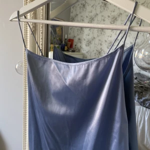 Nakd topp - Ljusblå topp i glansigt tyg från Nakd! Tunna band och korsad i ryggen⭐️