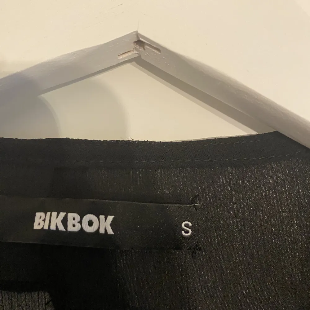En svart långärmad topp i mesh från BikBok,  med knytning fram. Aldrig använd Fraktas eller upphämtning i Västerås 💙 Köparen står för frakten 🩵. Blusar.