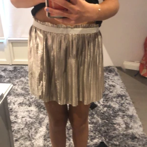 Glansig kjol - Jag säljer en silver kjol. Den är i barn stolek. Den har dubbelt tyg. Det är en silvrig glitter  resår i midjan. Inget tecken på användning💕