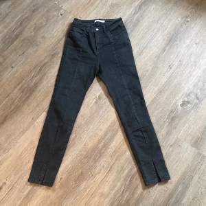 Svarta jeans med som och slits framtill från NA-KD.