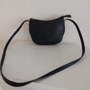 Svart axelremsväska - Svart axelremsväska från H&M, använd några gånger.