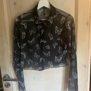 Svart tröja - Svart långärmad tröja med fjärilar som är genomskinlig. 