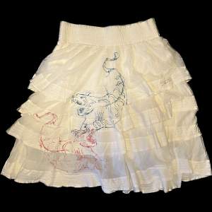 En vit vadlång kjol med tigrar på från Diesel! Stretchig i midjan och jättesöt :) i kjolen står det strl 30 och den sitter som en M, eftersom den är stretchig i midjan så anpassar den sig. 
