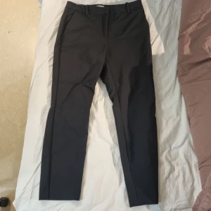 Svarta kostmbyxor känns som M - Står 42. Känns som M