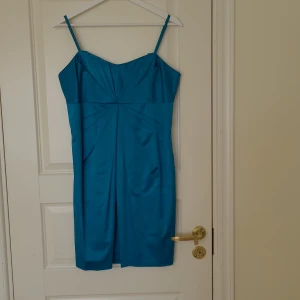 Festklänning  - Turkos festklänning i stl 40 säljes. Använd en gång på ett bröllop. Blixtlås i ryggen. 