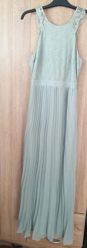 Ljusblå långklänning / balklänning  - Ljusblå balklänning, utmärkt till bröllop! Dragkedja där bak med öppen rygg och spettsöverdel. Helt ny, använd en gång! 