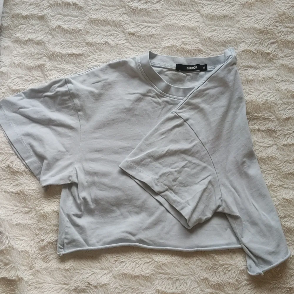 Ljus blå crop top. Vit/ljusblå/grå. Oanvänd utan tagg. Längd: 36cm. Finns också i ljus brun. T-shirts.