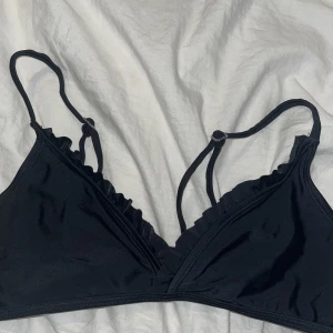 Svart volang bikini - Jätte fin bikini som aldrig kom till användning innan den blev för liten. Det står storlek 170 men skulle säga att den passar xs / lite mindre S 