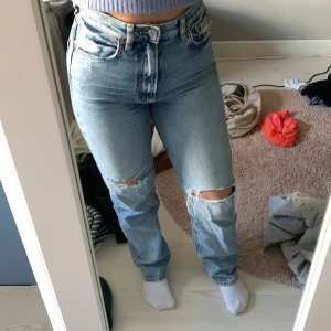 Raka jeans - Raka jeans med hål och hög midja. Sitter normalt i storleken. 