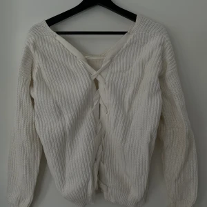 Stickad tröja med snörning - Stickad tröja med snörning som man själv kan välja vilket håll man vill ha snörningen.