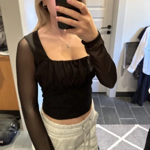 Festtopp i mesh - Svart festtopp med armar i mesh från Asos. Säljer pga köpt för stor storlek då jag är en 34
