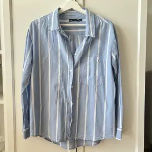 Supersnygg skjorta, blå med vita ränder, perfekt nu till sommaren. Tyvärr kommer den inte till användning hos mig. Använd max 2 gånger. Skicka ett meddelande vid frågor😊