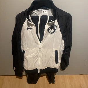 Nike Nba tracksuit  - Nike tracksuit (NBA Brooklyn Nets) i nyskick. Aldrig använt för endast 500. Både jackan och byxorna i Small.
