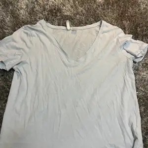 En v-ringad ljusblå t-shirt från H&M Basic i storlek S. Använd ett fåtal gånger, köparen står för frakten