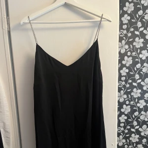 Svart sidenklänning  - Svart sidenklänning med diamantband. Perfekt till bal eller andra festligheter. Längden är till mitten av vaden ungefär. Storlek S/M.